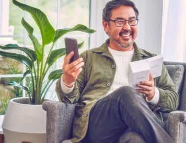 Smiling man holding IQOS
