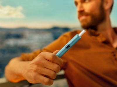 Mann hält ein IQOS ILUMA i Gerät