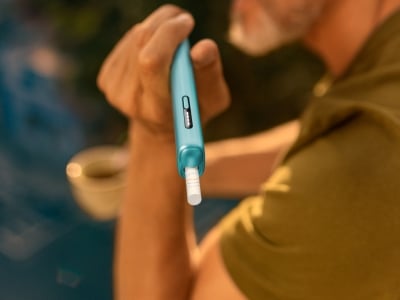 Main tenant un appareil IQOS ILUMA i ONE Blue