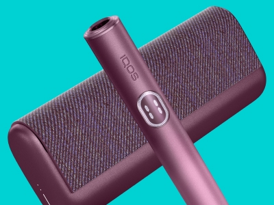 Appareil IQOS ILUMA i PRIME Garnet Red au-dessus son chargeur