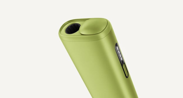 Green IQOS ILUMA i ONE inside its opened charger