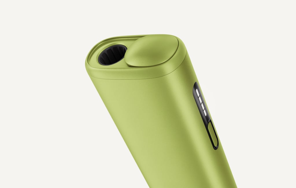 Green IQOS ILUMA i ONE inside its opened charger