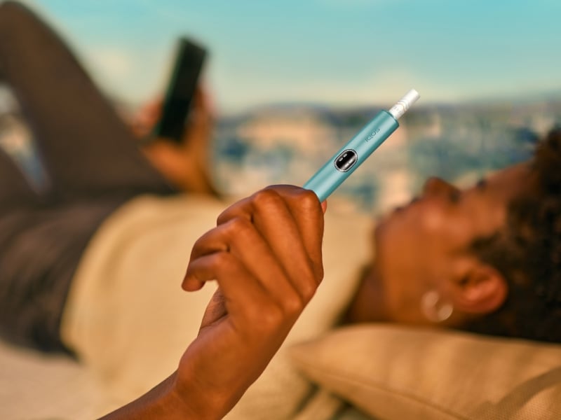 Person holding an IQOS ILUMA i device