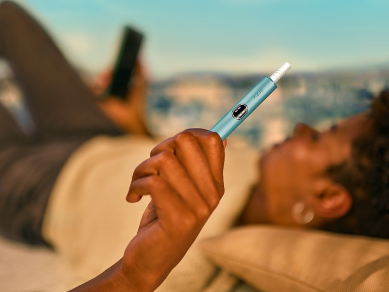 Person, die ein IQOS ILUMA i Gerät hält