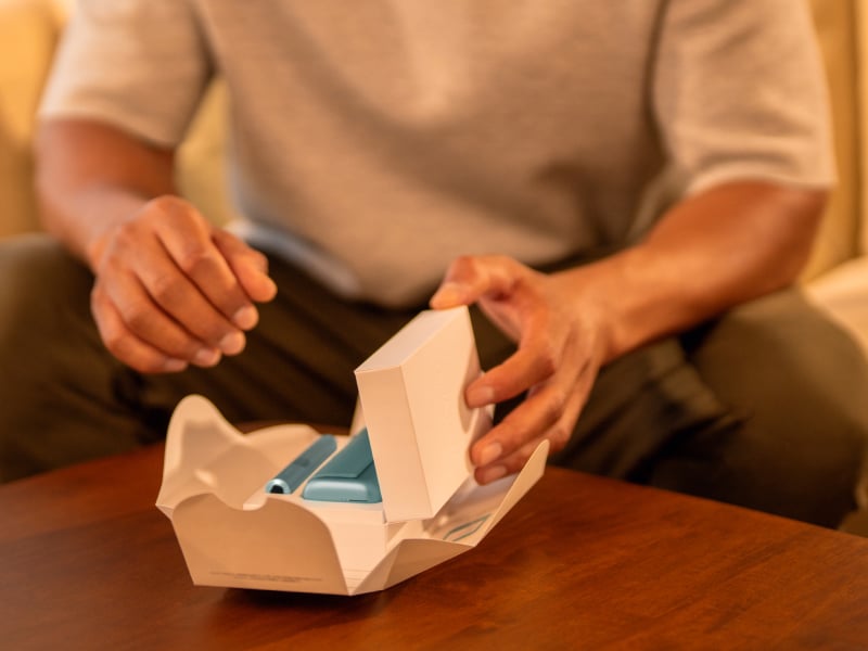 Man unboxing an IQOS ILUMA i PRIME device