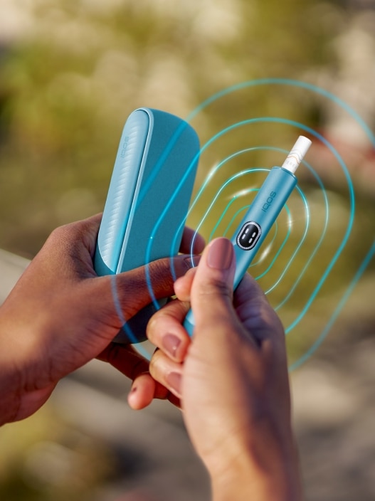Vue détaillée d’une main tenant un appareil IQOS ILUMA i Blue