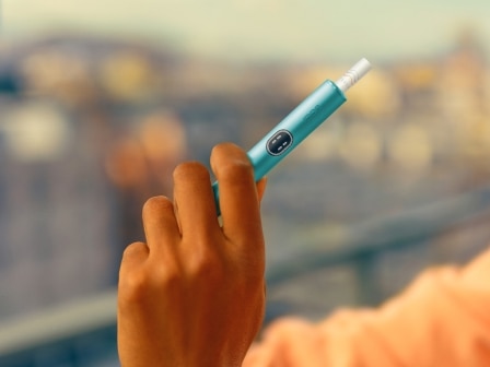 Vue détaillée d’une main tenant un appareil IQOS ILUMA i Blue