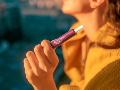 Donna con in mano un dispositivo IQOS ILUMA