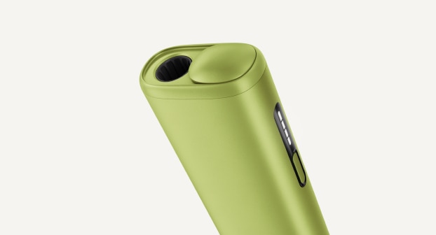 Green IQOS ILUMA i ONE inside its opened charger