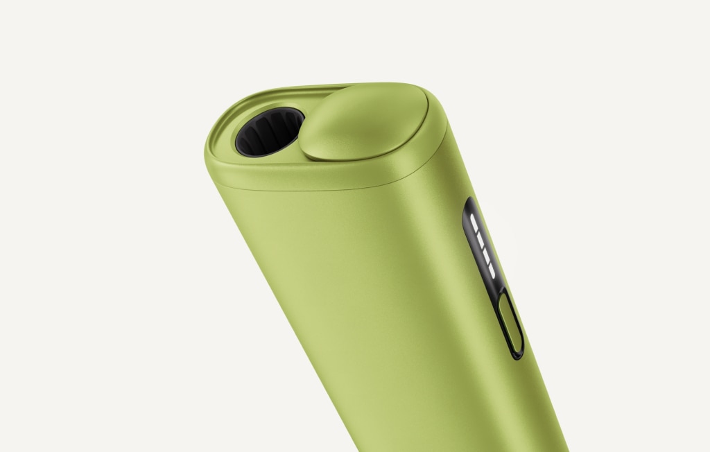 Green IQOS ILUMA i ONE inside its opened charger