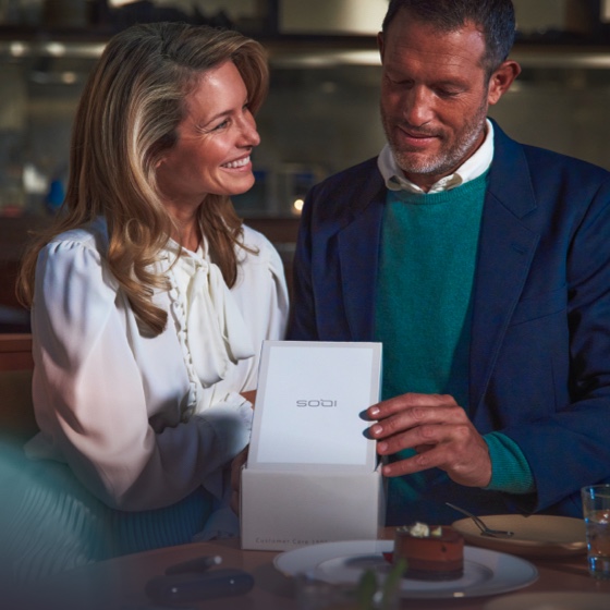 Man and woman unboxing a new IQOS device